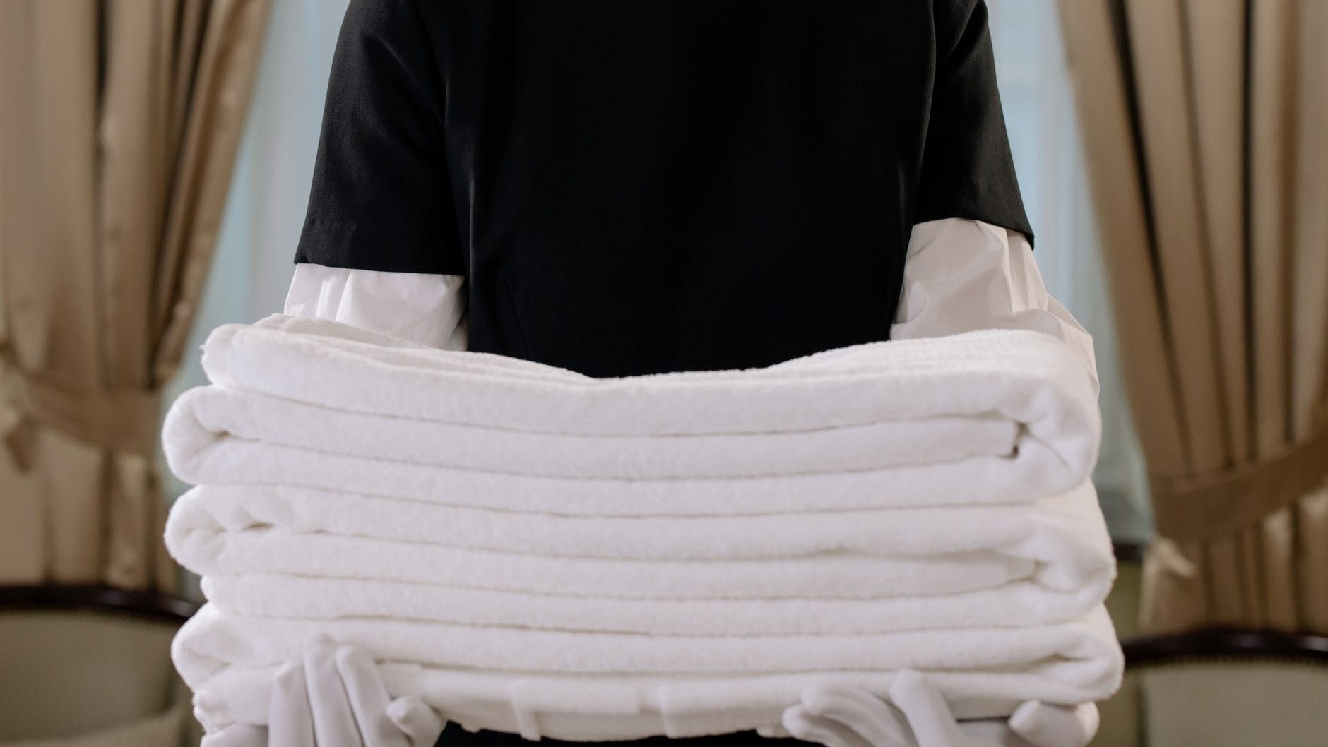 person holding a stack of white towels